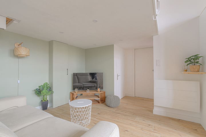 起居区配有舒适的沙发、电视柜和夹层下的装饰