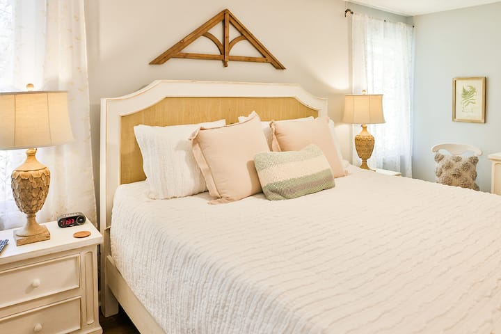 Large master bedroom suite with King size bed, 2 nightstands and large dresser with a 55 inch  Smart Tv and extra seating.