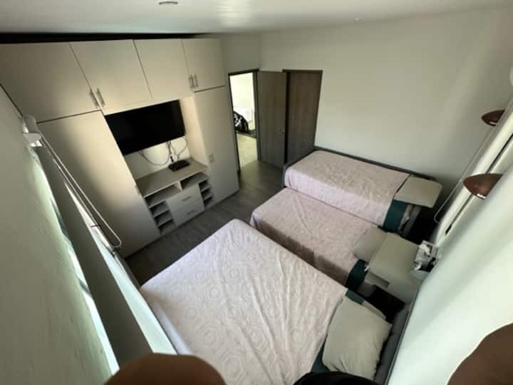 bedroom 1, two single beds, a double bed, TV with dish, full bathroom