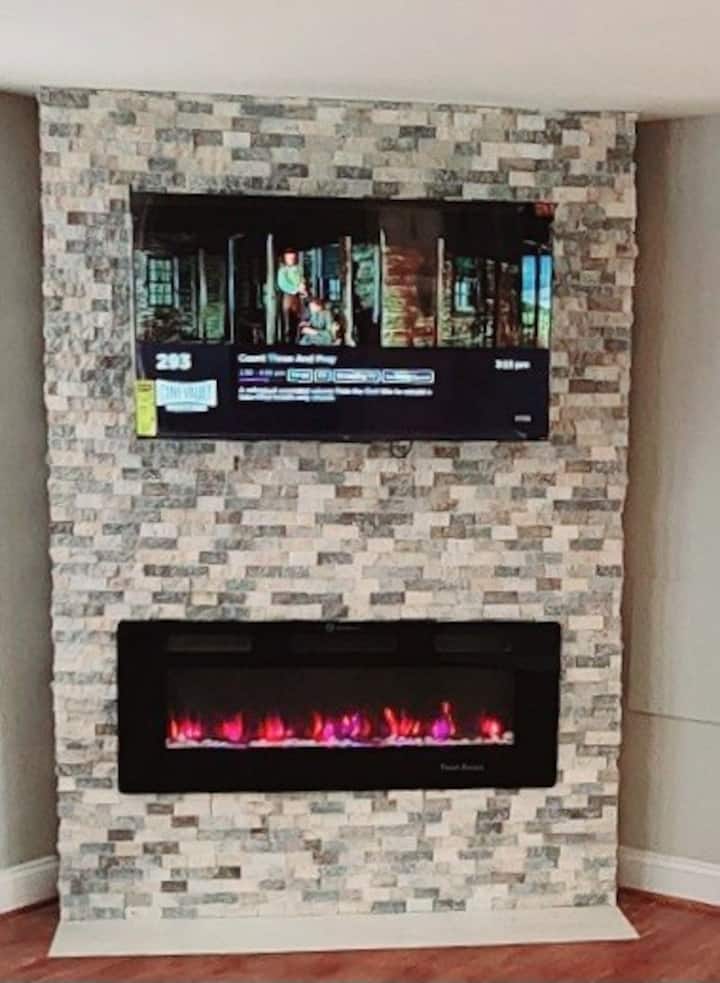 Отпуснете се, пред 50 - инчовия екран, гледайки любим филм, докато се успокоявате от топлинна електрическа камина, сгушена в величествена каменна мантия от пода до тавана.