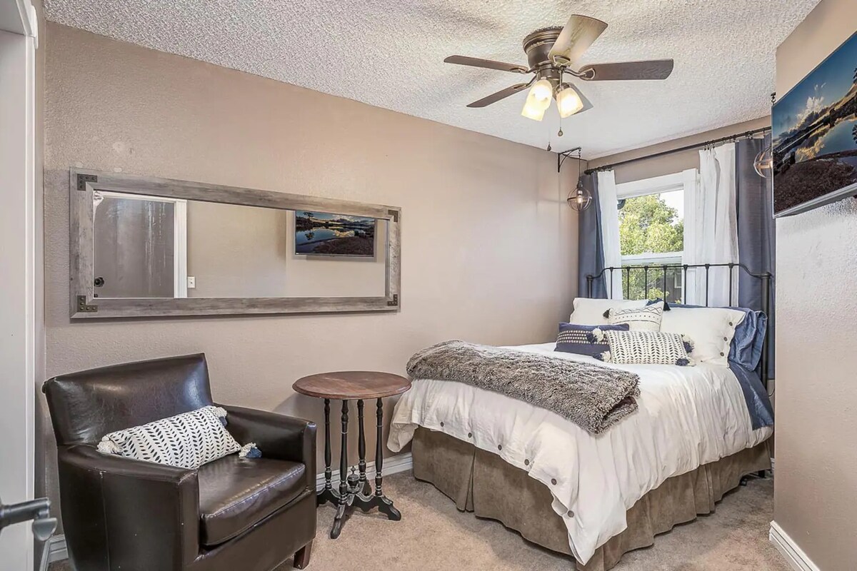 Krevet u punoj veličini, s udobnom stolicom za sjedenje i TV-om. 