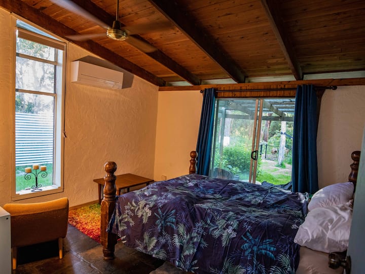 Bedroom 2 has views across the back lawn and into the national park. It also has split-system heating/cooling, a private sunbathing courtyard, a laid-back semi-private sitting area on the verandah, and best access of any room to the hammock and spa.