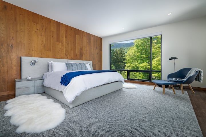 Chambre principale moderne avec lit King Size et vue magnifique sur la montagne.
