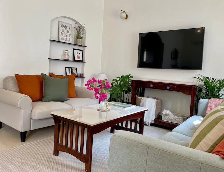 Living Room. 
Tropical theme with plants and earthy tones.