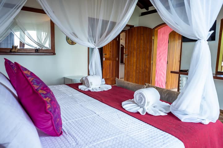 Chalet Rosa, suite 01.  Air 12,000 btu, smart tv 32", wifi,  minibar, cama doble king, mosquitera, cortinas opacas, ventilador de mesa, despacho casero independiente,  balcón, hamaca.  Vista al mar y piscina.
