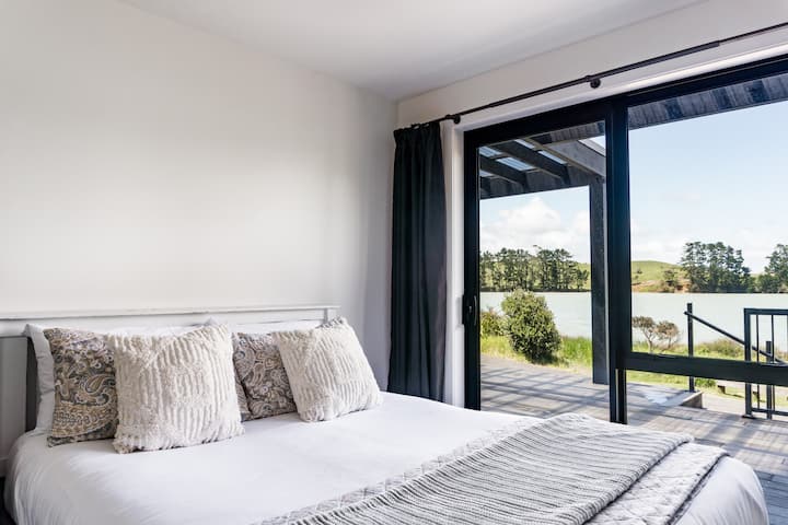 Საძინებელი სამი საწოლით, წყლის ხედებით და წინა გემბანზე სლაიდერის კარით.