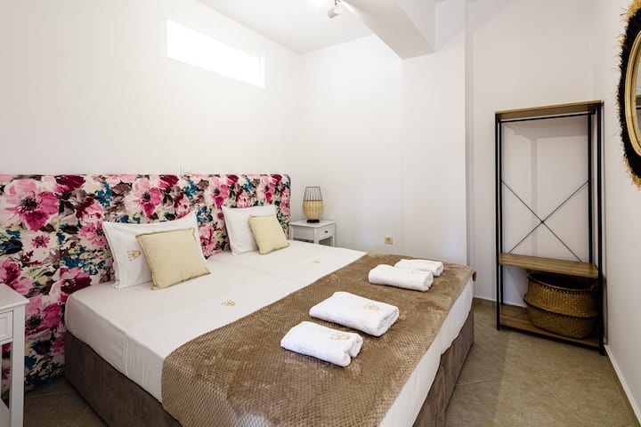 Tercer dormitorio doble en la villa con un colorido cojín de flores en la pared.