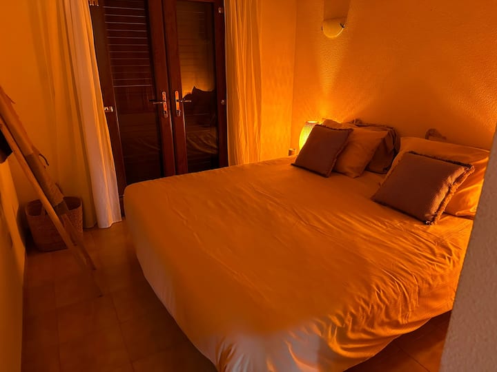 Dormitorio 1 con vigas españolas originales, puertas, armario empotrado y puertas francesas al balcón.