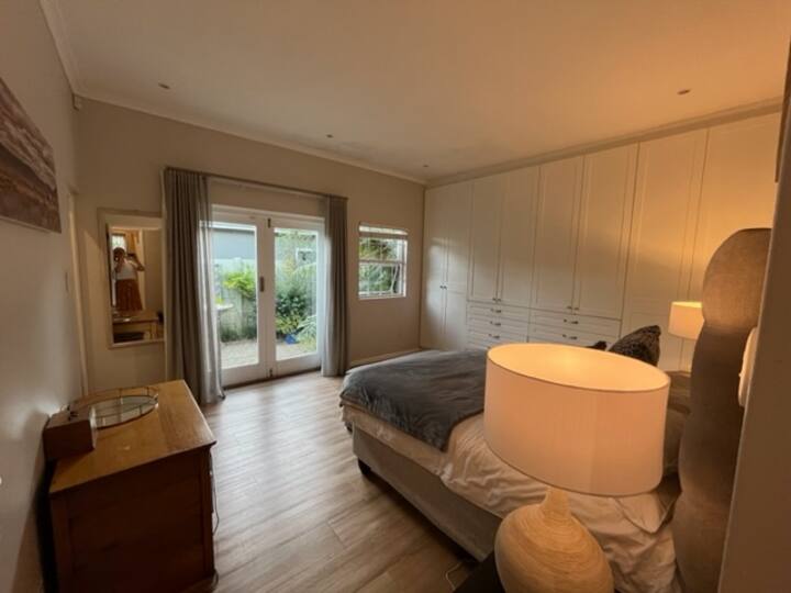 חדר שינה ראשי עם מיטת קווין סייז וחדר רחצה צמוד.