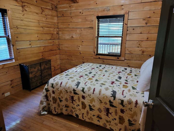 ห้องนอนควีนไซส์ที่ Black Bear Cabin มีที่พักผ่อนที่อบอุ่นและน่าอยู่พร้อมเตียงขนาดควีนไซส์ ผ้าปูที่นอนนุ่มและเสน่ห์แบบชนบท ที่พักที่เงียบสงบนี้ให้ความสะดวกสบายและผ่อนคลาย เหมาะสำหรับการนอนหลับพักผ่อนยามค่ำคืน