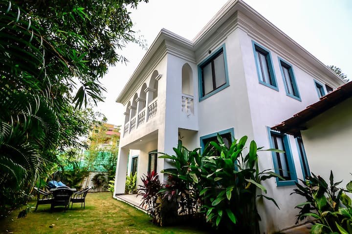 Lawn with lush green grass and outdoor seating with beautiful trees and plants. our guests enjoy a quiet and peaceful session of Yoga here early in the mornings and a relaxing meal and a glass of wine as the sun sets.