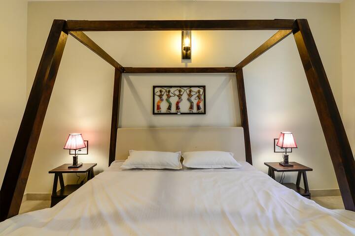 The Bed room on the ground floor is delectably done up with help of some local goan handicrafts and calm lighting to help you relax and comes with a view which opens into a beautiful mini garden featuring beautiful potted plants.