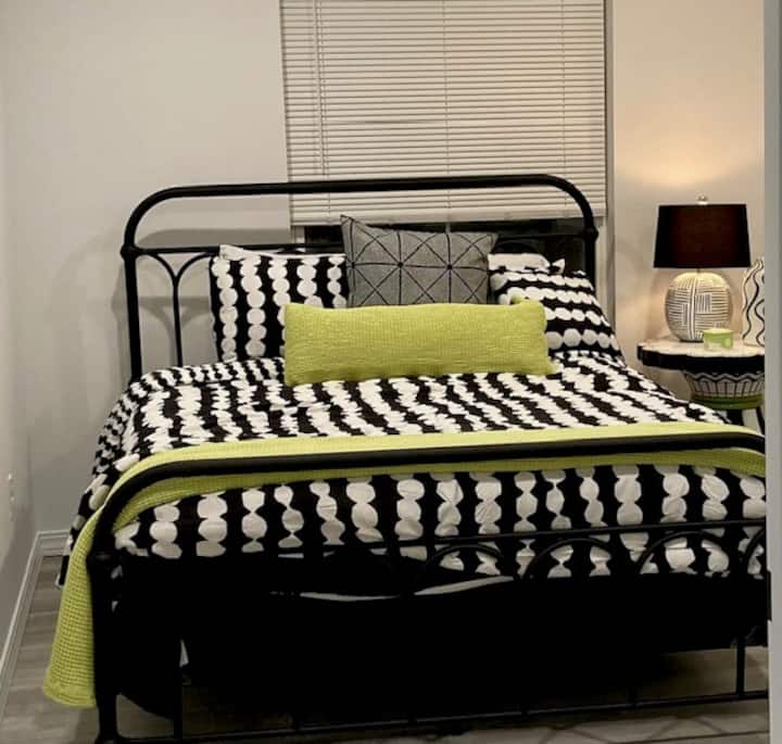 First floor Queen bedroom that includes a seating area and SmartTV.  The room also has private access to the patio area.  A full bathroom and closet are located directly across the hall.  