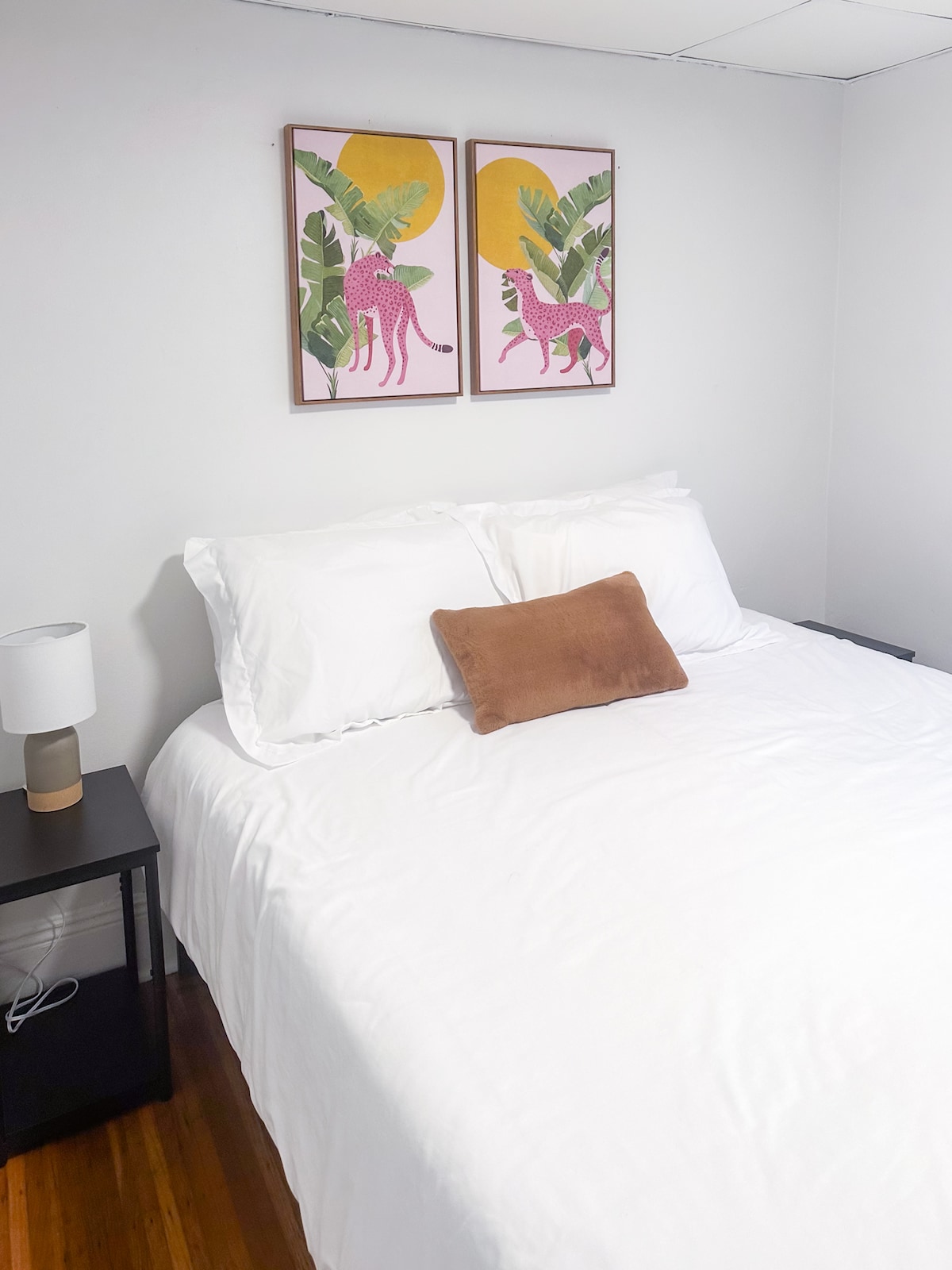 La première chambre sur le côté droit offre un lit queen size confortable, des tables de nuit de chevet, une commode compacte pour le rangement et un placard.