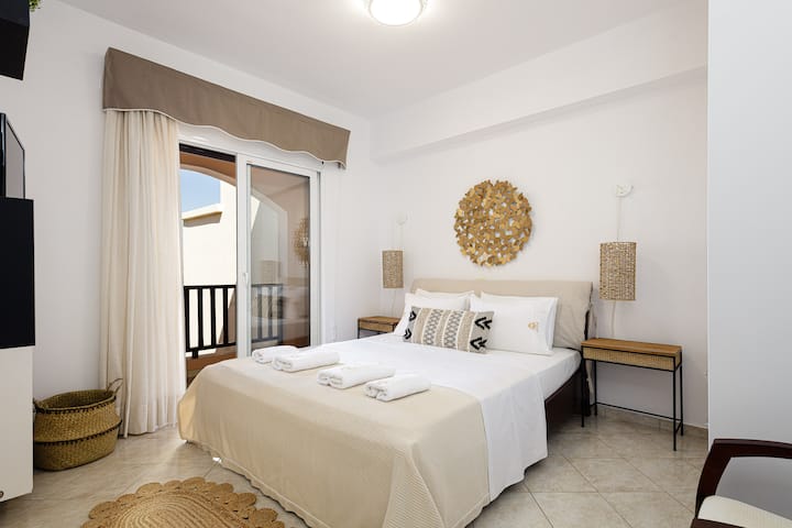 Spavaća soba s bračnim krevetom i toniranim bojama.