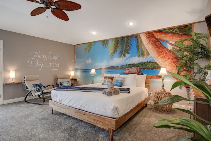 Chumba kikubwa cha kulala cha paradiso kilicho na kitanda kikubwa, sehemu za kukaa, na kitanda cha ziada cha siku kilicho na magodoro 2 pacha (inavyoonekana kwenye picha nyingine).