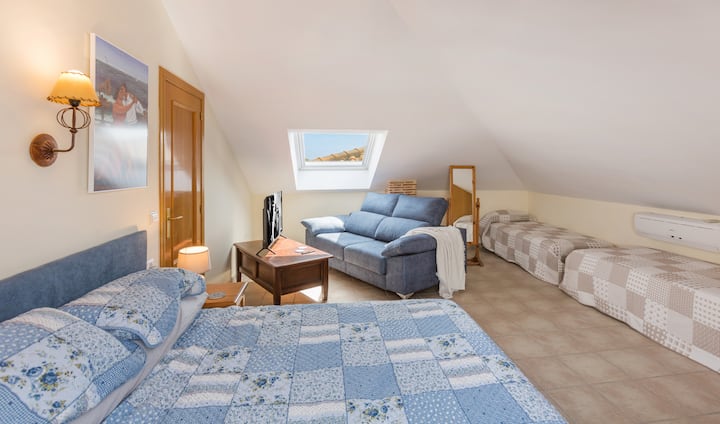 أول غرفة نوم كبيرة في الطابق العلوي مع سرير أريكة وتلفزيون