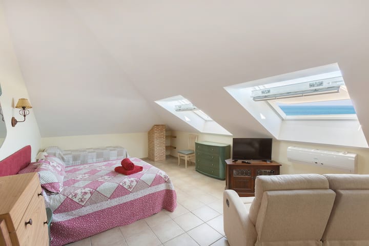 غرفة نوم كبيرة ثانية في الطابق العلوي بإطلالة على المحيط وأريكة وتلفزيون