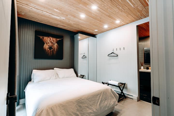 The Cow bedroom with queen size bed and medium firm mattress. Beautiful aromatic natural cedar ceiling. Heated floor and huge window to enjoy the view and also blind curtains to help you sleep better.