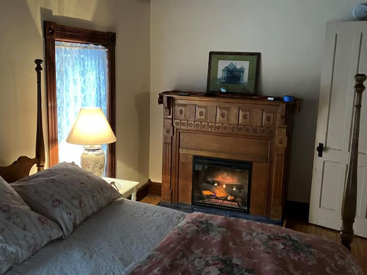 Second floor rear bedroom with double four poster bed and electric fireplace