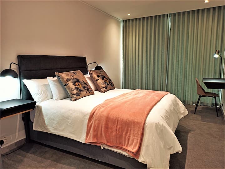 Kitanda cha ukubwa wa kifalme katika chumba kikuu cha kulala, kilicho na kituo cha kazi, kinachofuata na kufunguka kwenye mtaro wa mawio ya jua.