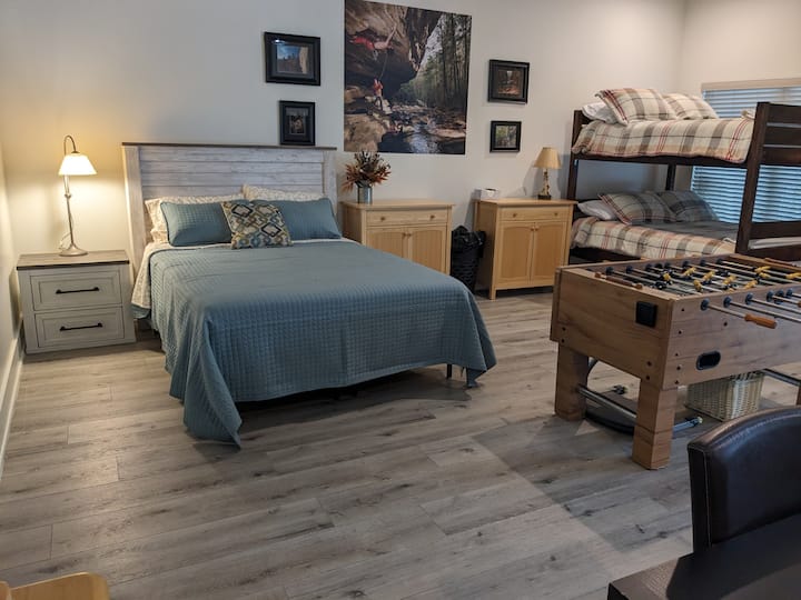 Lit queen size au sous-sol à côté d'un lit superposé complet.