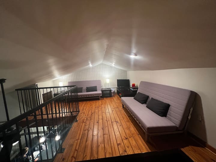 Área de loft con dos futones. Televisión con chimenea y juguetes para los niños. 
