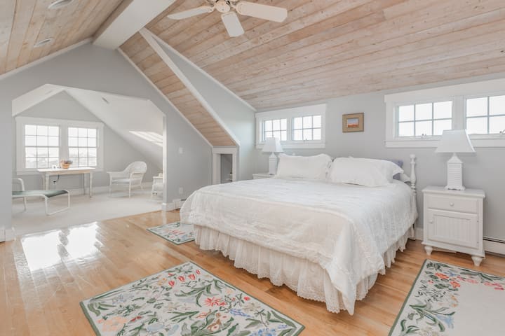 Dormitorio principal con sala de estar y cama tamaño king. 