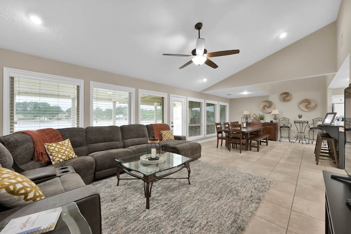 Трапезарията се отваря към всекидневната, оборудвана с разтегателен диван с шезлонг и телевизор с плосък екран с достъп до стрийминг. Стената на прозорците предлага постоянна гледка към езерото. Излезте от вратата, за да се насладите на горната палуба със стълби към долната част.