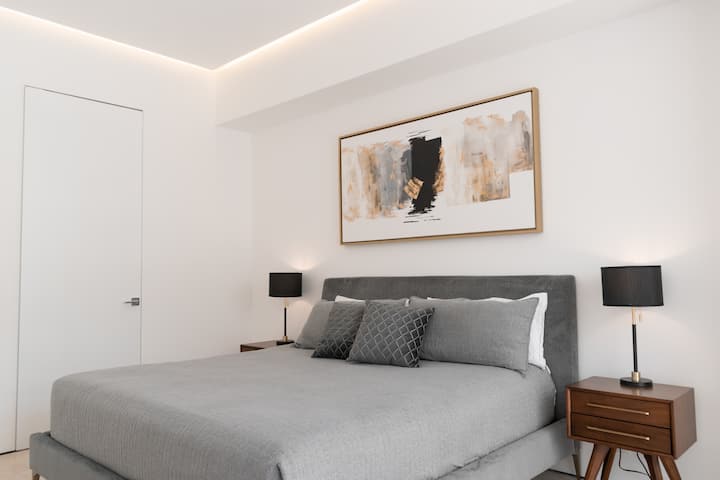 King size bed and dress in the primary bedroom with ensuite bathroom and closet.