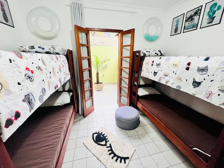 Quarto com uma cama de casal, uma beliche e 2 colchões extras, ar condicionado, ventilador de teto, ventilador extra, armário e acesso ao quintal