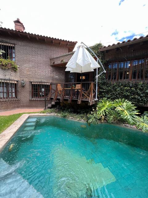 A central house with a swimming pool and large garden