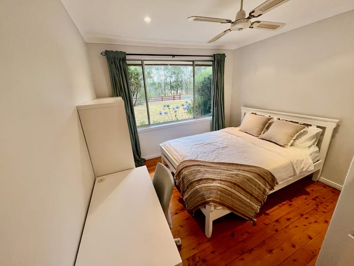 ห้องนอนพร้อมเตียงควีนไซส์และพื้นที่ทำงาน/การศึกษา