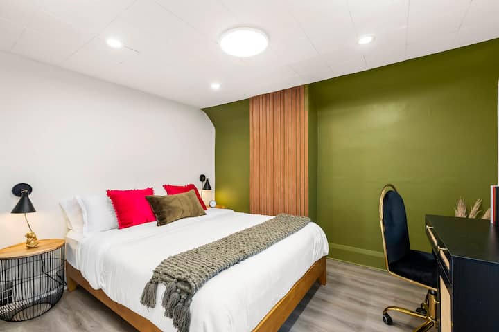 Elegante dormitorio con magnífica pared de acento y divertidos toques de color en todas partes.