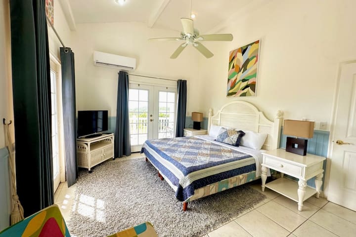 One of two master bedrooms. Enjoy the king bed, peaceful artwork, and views of the ocean. Each bedroom has an attached closet and spacious bathroom. 