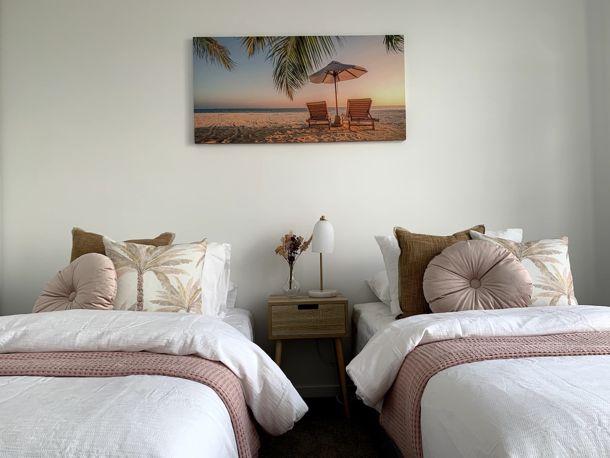 Deuxième chambre équipée de deux lits simples, peignoir intégré et stores occultants.