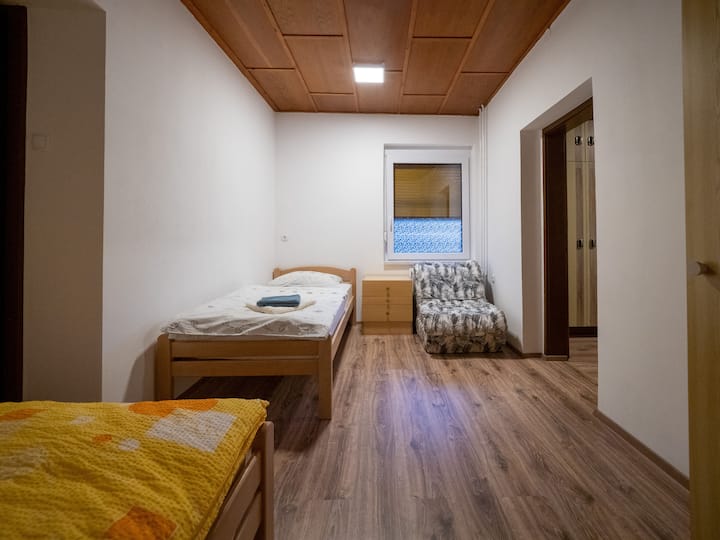 Soba s dva kreveta i ormarom.