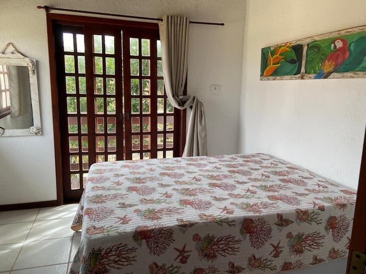 Горна спална соба за гости со врата до балкон.