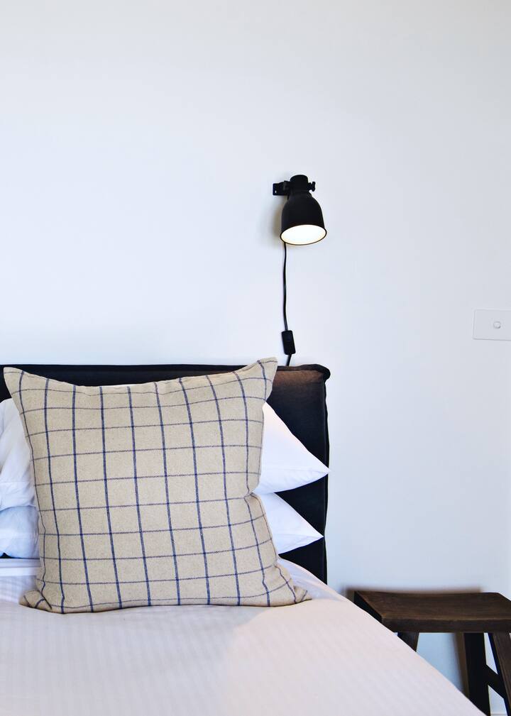 Main bedroom with plush bedding and linen service included in your stay.