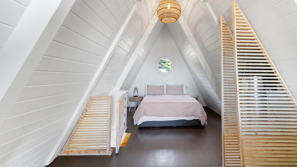 Upstairs bedroom with queen size bed and dreamy porthole window
