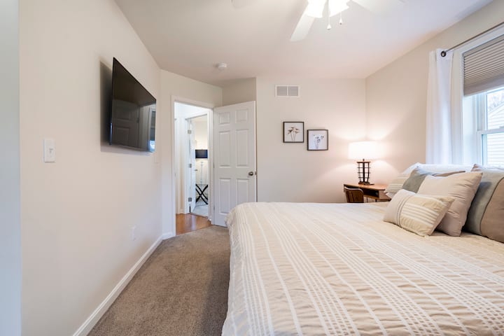 Primary Bedroom with King bed, 55 inch flat screen, office desk and chair, and private full bathroom.