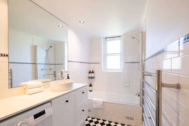 Updated bathroom with new modern sink and washing machine.