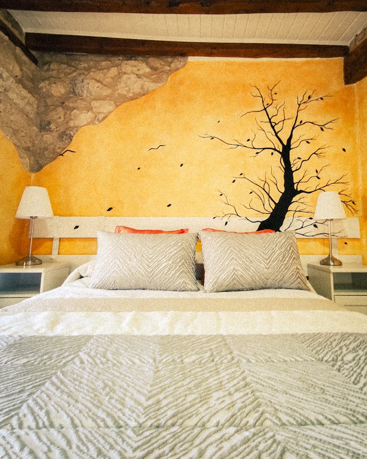 Chumba cha "Vuli" kilicho na mti uliopakwa rangi ukutani. Harusi 