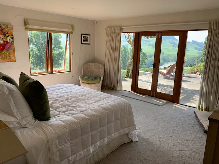 Chumba kikubwa cha kulala na Superking kufungua nje ya baraza na maoni ya mto na kilima