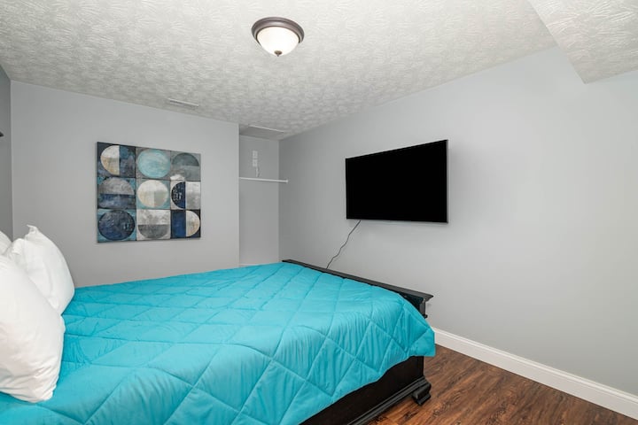 Posledná spálňa v suteréne má manželskú posteľ, televízor s plochou obrazovkou a závesný priestor na oblečenie.