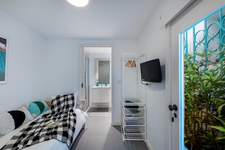 Small bedroom, en suite and tv. This bedroom as outside light from both a window and a door to a small internal patio