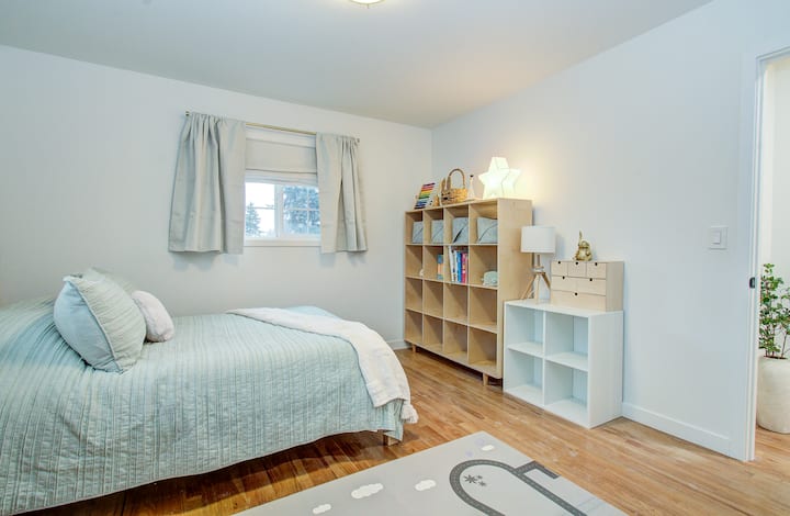 Habitación para niños con cómodo colchón tamaño queen. Algunos juguetes y libros para los más pequeños, además de cortinas opacas adicionales.