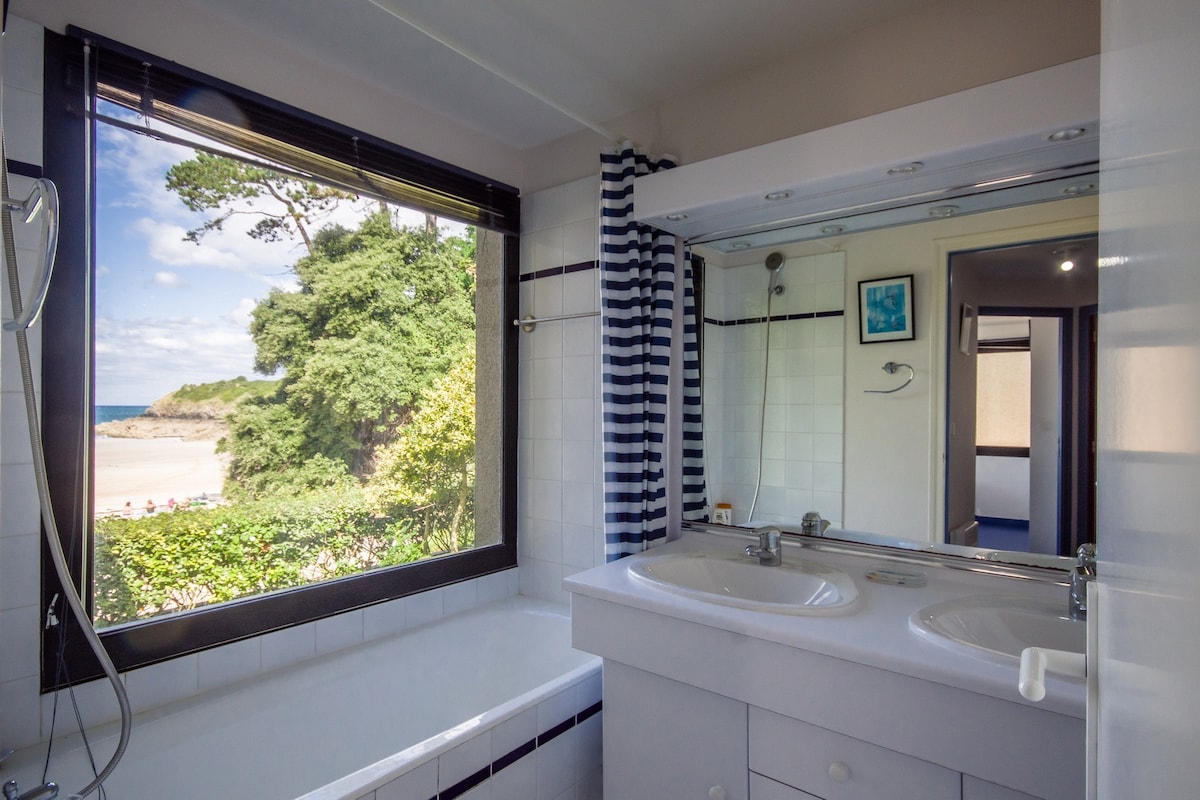 Salle de bain avec baignoire et vue mer