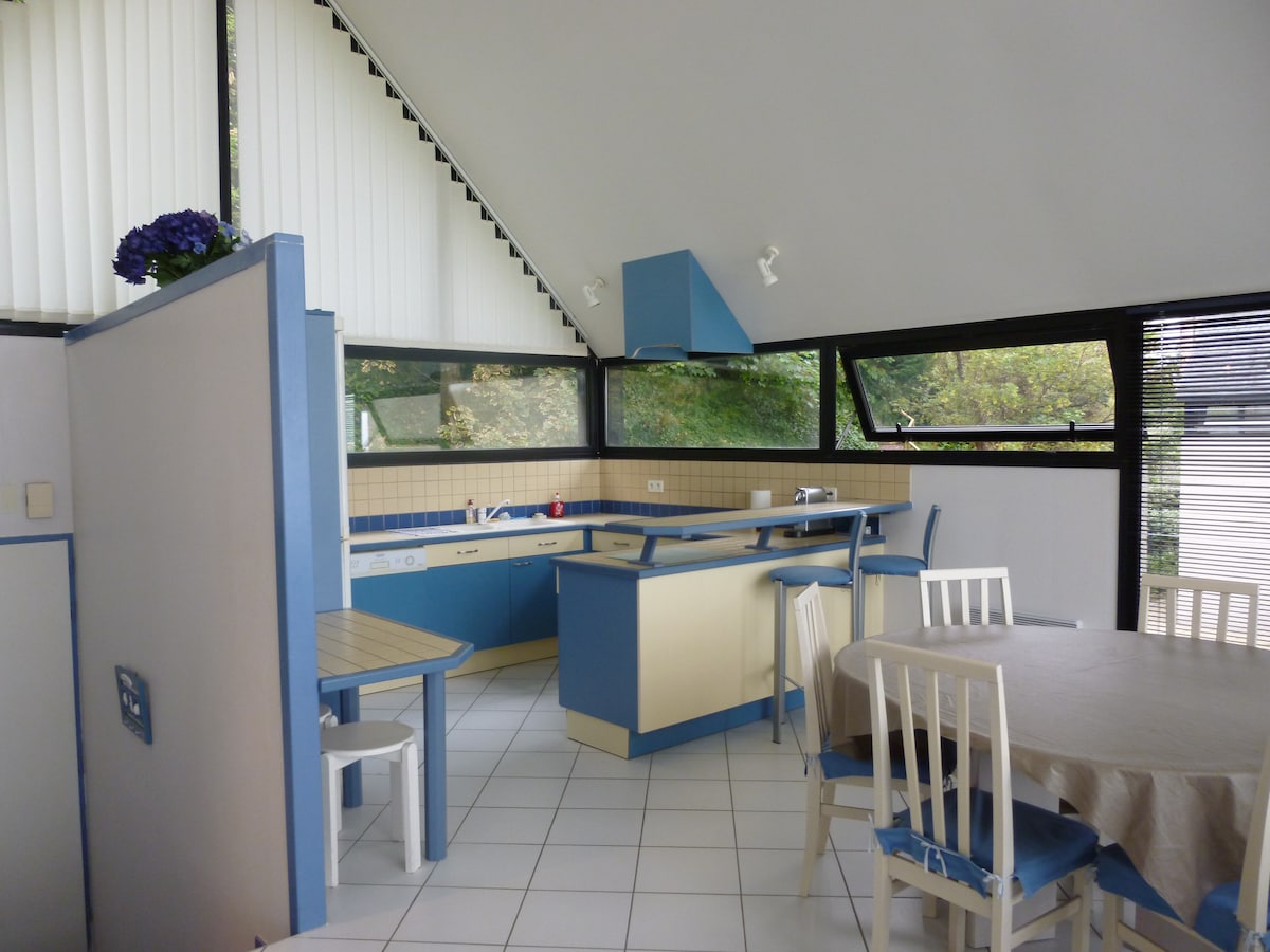 Cuisine equipee avec ilot central et grandes fenetres