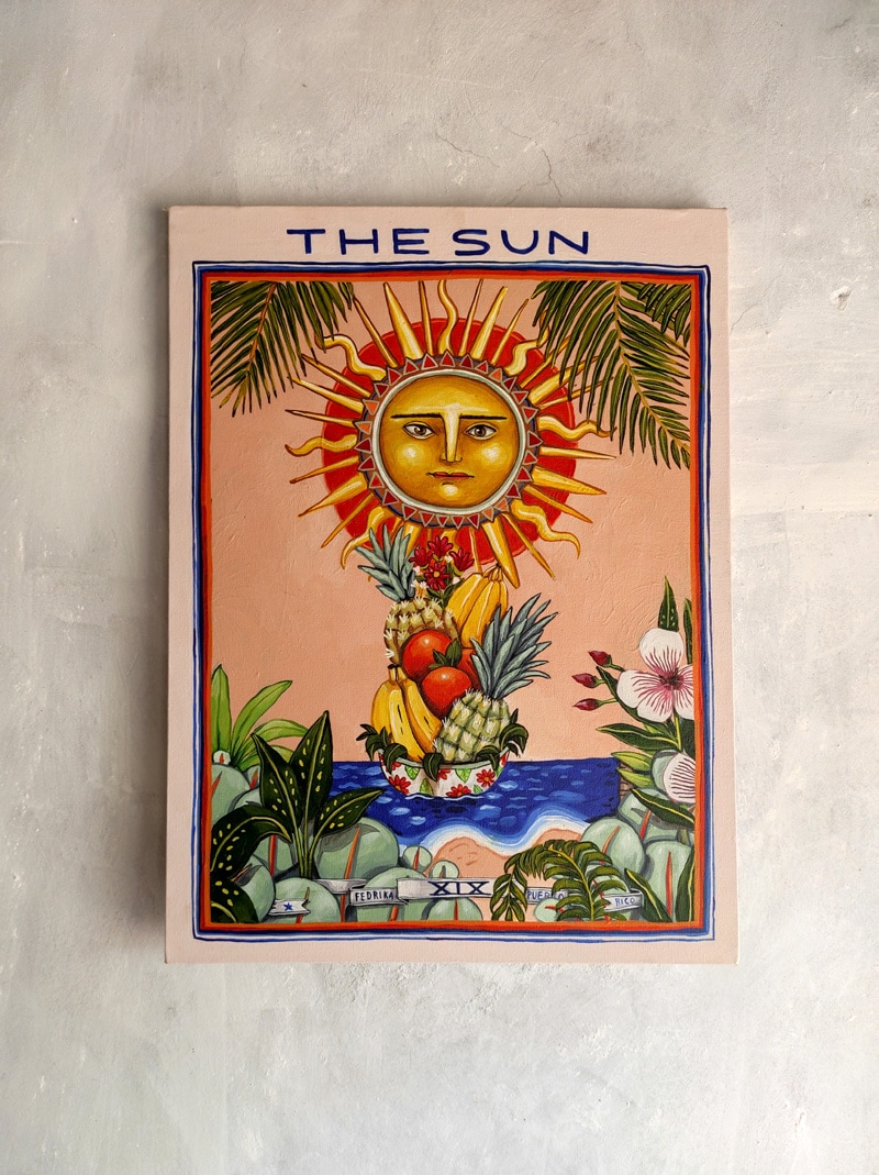 A vibrant artwork is displayed on a textured wall, featuring a sun surrounded by an arrangement of tropical fruits and flowers. The colors are bright, and the design conveys a sense of warmth and nature, offering a joyful focal point in the space.